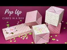 some pink boxes with flowers on them and confetti