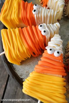 halloween candy sticks with googly eyes on them sitting in a pan, ready to be eaten