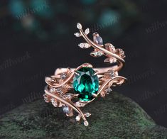 a ring with an oval green stone surrounded by leaves