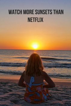 a woman sitting on top of a sandy beach next to the ocean with text overlay that reads, watch more sunsets than netflix