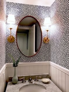 a bathroom sink with a mirror above it and a vase on the counter next to it