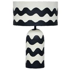 a black and white table lamp with a large shade on it's base,