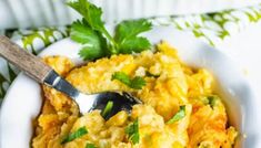 a white bowl filled with eggs and garnished with parsley