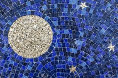 a blue and white mosaic tile wall with a gold star on the center in the middle