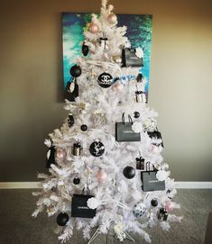 a white christmas tree decorated with black and white ornaments