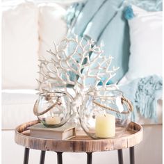 two glass vases sitting on top of a wooden table next to a white couch