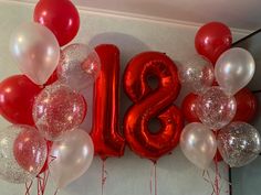 balloons and streamers are arranged in the shape of the number twenty eight on a wall