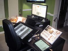 a computer desk with two monitors on top of it and other electronic devices sitting next to each other