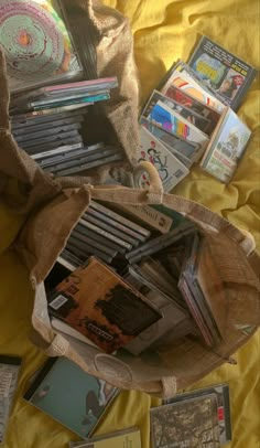 there is a bag full of books and cds on the bed with it's contents