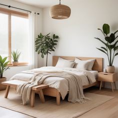 a bed sitting in a bedroom next to a window with potted plants on it