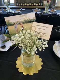 a vase filled with flowers sitting on top of a table next to a card and photo