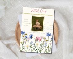 a card with an image of a baby sitting on a bench surrounded by flowers and daisies