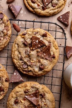 chocolate chip cookies cooling on a wire rack with milk and almonds next to them