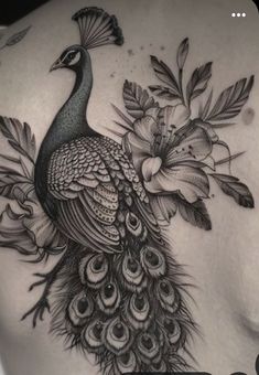 a woman's back with a peacock and flowers on it