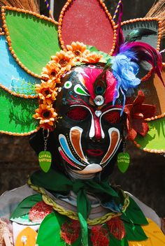 a colorful mask with feathers on it's head