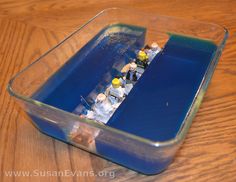 a plastic container filled with small figurines sitting on top of a wooden table