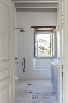 an open door leading to a bathroom with a window