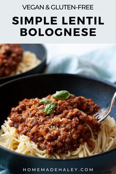 a bowl filled with spaghetti and sauce on top of a blue cloth next to a fork