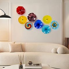 a living room filled with white furniture and lots of different colored flowers on the wall