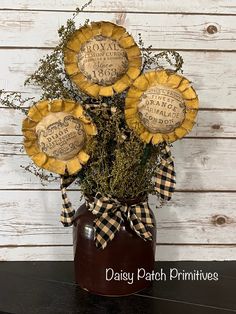 three sunflowers sitting in a vase on top of a table