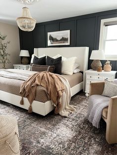 a bedroom with black walls, white furniture and an area rug on the floor that matches the bed