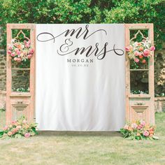 a wedding sign with flowers and greenery on it