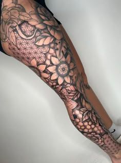 a woman's leg with tattoos and flowers on it