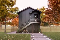 a small house with stairs leading up to the second floor and a bike parked in front of it