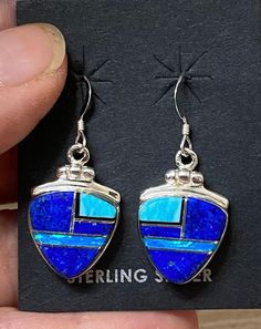 "This beautifully well crafted Triangle Berry shape Dangle earrings are handmade by a Navajo Artisan. The Colors of the Earrings come from Lapis Lazuli, Turquoise and Blue Opal. They are stamped Sterling and signed by the Artist. The Earrings measure 1 3/8\" long and a bit over 1/2\" wide. There are two different pairs available and they will vary in color. \"Winds of Wisdom\" (Lapis Lazuli, Turquoise and Blue Opal. The Navajo (Dine') believe that the wind is a powerful source. The native tradit Artisan Blue Jewelry With Inlay, Southwestern Style Blue Pierced Earrings, Southwestern Blue Earrings For Pierced Ears, Southwestern Style Blue Earrings For Pierced Ears, Artisan Blue Earrings, Artisan Blue Nickel-free Earrings, Blue Inlay Earrings For Gifts, Unique Blue Sterling Silver Earrings, Blue Inlay Earrings For Gift