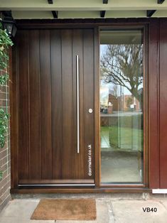 the front entrance to a home with wooden doors and sidelights on either side of the door