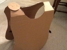 a cardboard box that is sitting on the floor in front of a chair and table