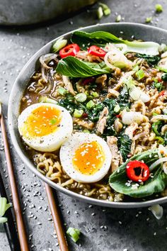 a bowl filled with noodles, eggs and vegetables