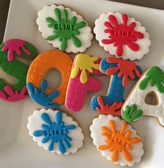 decorated cookies on a plate with the word smile spelled out in different colors and shapes