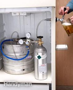 a man pouring beer into a keg in an open refrigerator with the door open