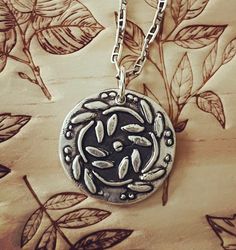 "This Circle of Growth pendant is made from .999 fine silver. The circle also represents the cycle of life, infinity and the changing seasons.  The impression was from a wax seal stamp.  7/8\" diameter. Each one is unique as the process is done by hand and not a press. The one you order will look as close to the picture as possible but no two are exactly alike. This is a process of many steps involving forming, drying, firing, hand polishing and the final patina gives and antique look. If you want the silver to be shiny, I can leave off the antique patina." Nature-inspired Silver Hand Stamped Jewelry, Oxidized Sterling Silver Medallion Necklace, Sterling Silver Medallion Necklace With Oxidized Finish, Sterling Silver Oxidized Medallion Necklace, Silver Medallion Necklace Hand Stamped, Silver Medallion Necklace For Meditation, Nickel-free Sterling Silver Medallion Necklace, Antique Silver Stamped Round Necklaces, Nickel-free Sterling Silver Round Medallion Necklace