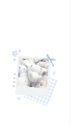 a white teddy bear in a blue and white checkered box with stars around it