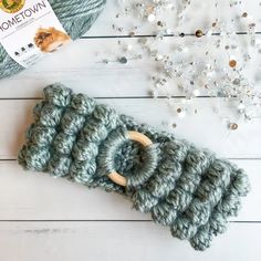 a crochet hook is laying next to some beads and a ball of yarn