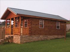 a small log cabin with a metal roof and steps leading up to the front door