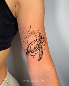 a woman's arm with a turtle tattoo on it