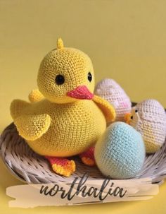 there is a stuffed duck in the basket with other knitted toys next to it