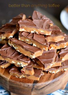 a wooden bowl filled with chocolate and pretzels on top of a blue table cloth