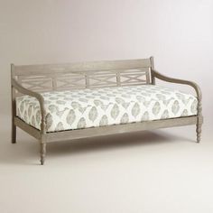 an old style daybed with white and gray fabric on the top, in front of a plain background