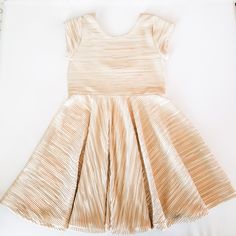 Show stopping metallic gold pleated twirl dress for those fancier occasions.This metallic gold pleated stretch fabric mixes high fashion with fun, allowing your little one to look chic without loosing the able to twirl the day away! From birthdays, to weddings, tea parties, Easter and the holidays, it's a dress your daughter can enjoy all year long!Made with a luxurious and lightweight metallic gold and ivory pleated knit fabric that offers the perfect amount of stretch and buttery softness that Pleated Knit, Twirly Dress, Girls Holiday Dresses, Gold Girl, Twirl Dress, Special Dresses, Tea Parties, Modern Square, Star Dress