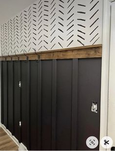 the inside of a building with black doors and white wall paper on the walls behind them