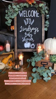 a welcome sign is surrounded by candles and pumpkins