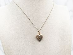 Declare your love with this charming yellow gold etched heart-shaped locket! It's the perfect way to share your secrets and wear your heart on your sleeve.This pendant does not come with the chain shown. Please feel free to contact us, we will help you find the perfect chain for your style and budget!Metal: 14K Yellow GoldMeasurements: 16 x 25 mm, with bailMarks: "14K ESEMCO" Stamped on the inside Vintage Charm Heart-shaped Yellow Gold Jewelry, Yellow Gold Heart Jewelry With Vintage Charm, Yellow Gold Heart Necklace With Vintage Charm, Valentine's Day Heirloom Locket Necklace With Heart Charm, Heirloom Locket Necklace With Heart Charm, Heirloom Heart Charm Locket Necklace, Yellow Gold Heart Pendant Locket With Vintage Charm, Yellow Gold Heart Pendant Locket Necklace With Vintage Charm, Yellow Gold Heart Locket Necklace For Keepsake