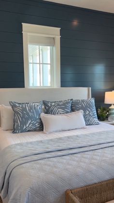 a bedroom with blue walls and white bedding