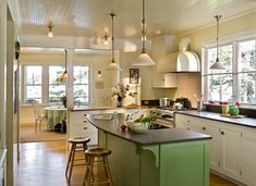 a kitchen with green island and white cabinets