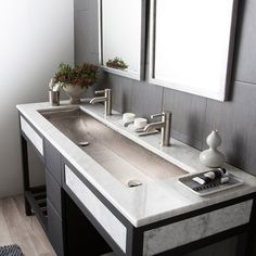 a bathroom with double sinks and mirrors on the wall