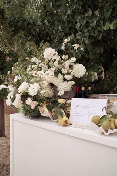 white flowers and fruit are on display in front of a sign that reads, love